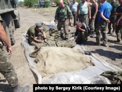 Сергій Кирик «підписує» тіла побратимів. Після танкової атаки російських гібридних сил. Донбас. 4 липня 2014 року.