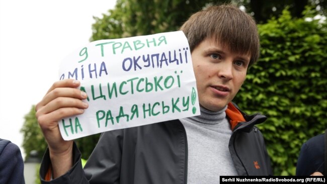 Участник акции в центре Киева с плакатом "9 мая - смена нацистской оккупации на советскую!"