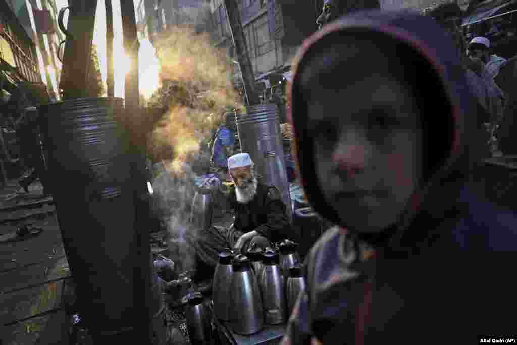 Afghan tea seller Farooq Shah fills kettles for customers at a marketplace in Kabul. (AP/Altaf Qadri)