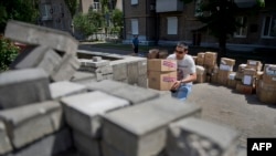 A man carries boxes containing food and medical supplies received as humanitarian aid at the self-proclaimed "Donetsk People's Republic" administration headquarters in Donetsk in June.