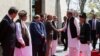 Abbasi (right) shakes hands with Afghan officials in Kabul.