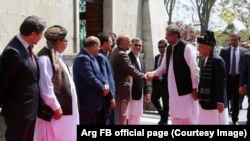 Abbasi (right) shakes hands with Afghan officials in Kabul.