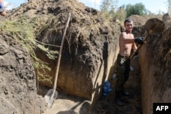 Украинский солдат копает траншею на окраине Мариуполя