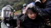 Поліція намагається затримати учасника протесту на виході зі студентського містечка Політехнічного університету Гонконгу. 18 листопада 2019 року