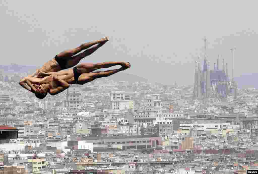 Mexico's Ivan Garcia and German Sanchez perform a dive during a practice for the men's synchronised 10-meter platform event with a backdrop of the Sagrada Familia Cathedral at the Montjuic municipal pool in Barcelona. (Reuters/Albert Gea)