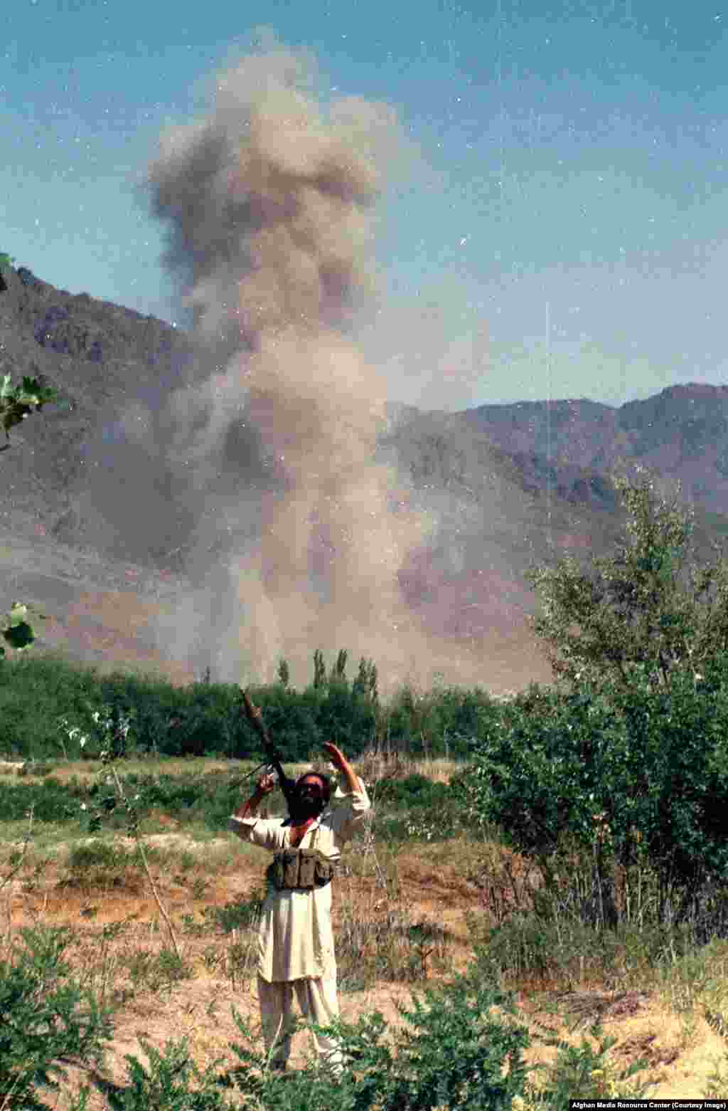 A mujahedin fighter scans the sky after an air strike. As conditions became increasingly risky for foreign journalists inside Afghanistan (in 1984 a Soviet diplomat vowed any journalist caught with mujahedin fighters would be killed), Washington also funded a controversial program to supply Afghan rebels with cameras.