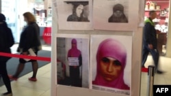 People walk past an information banner with the photos of terrorism suspects in a department store in the Russian Black Sea resort of Sochi on January 18.