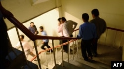 Pakistanis leave an office building after an earthquake in Karachi on September 24.