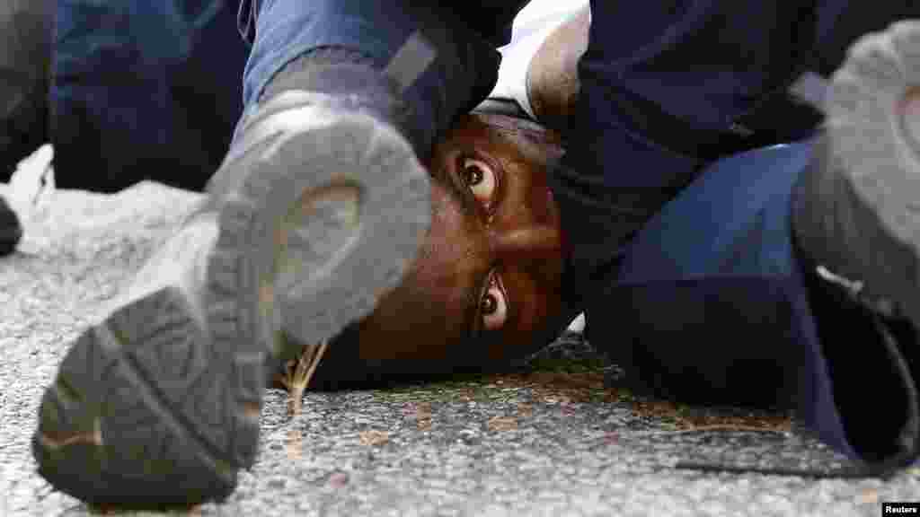 აშშ-ის ქალაქ ბატონ რუჟში პოლიცია აკავებს დემონსტრანტს, რომელიც ოლტონ სტერლინგის მოკვლას აპროტესტებდა. (ფოტო: Reuters)