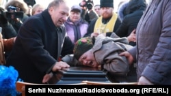 Mourners weep on the coffin carrying Iryna Nozdrovska in her hometown of Demydiv on January 9.
