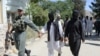 A member of the Afghan security forces escorts alleged Islamic State fighters being presented to the media at the police headquarters in Jalalabad on May 29.