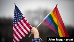 Флаг США и радужный флаг — символ ЛГБТ-движения.