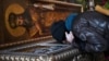 Вірянка цілує раку з мощами св. Макарія, митрополита Київського, Володимирський собор, Київ, 13 березня 2020 року