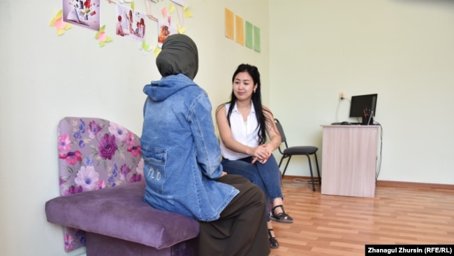 Эвакуированная из Сирии жительница Актобе (сидит спиной) в реабилитационном центре разговаривает с психологом. Актобе, 30 июля 2019 года.