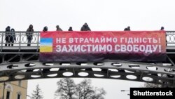 Банер із написом «Не втрачаймо гідність! Захистимо свободу!», який громадські активісти вивісили на пішохідному мосту на алеї Героїв Небесної сотні з нагоди 7-ї річниці початку Революції гідності. Київ, 21 листопада 2020 року