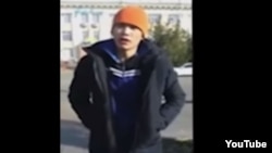 Өзін-өзі өртеу алдында "Нұр Отан" партиясы ғимараты алдында сөйлеп тұрған Ерлан Бектібаев. Youtube желісіне жарияланған видеодан алынған скриншот. Тараз, 24 қазан 2015 жыл.