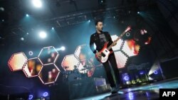 Британская группа Muse (на снимке - ее гитарист Кристофер Уолстенхольм) представила гимн Олимпиады-2012