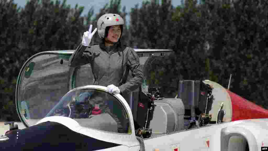 A member of China's first batch of female fighter pilots gestures from her aircraft in August 2009, when authorities said they were recruiting taikonauts from that elite group.