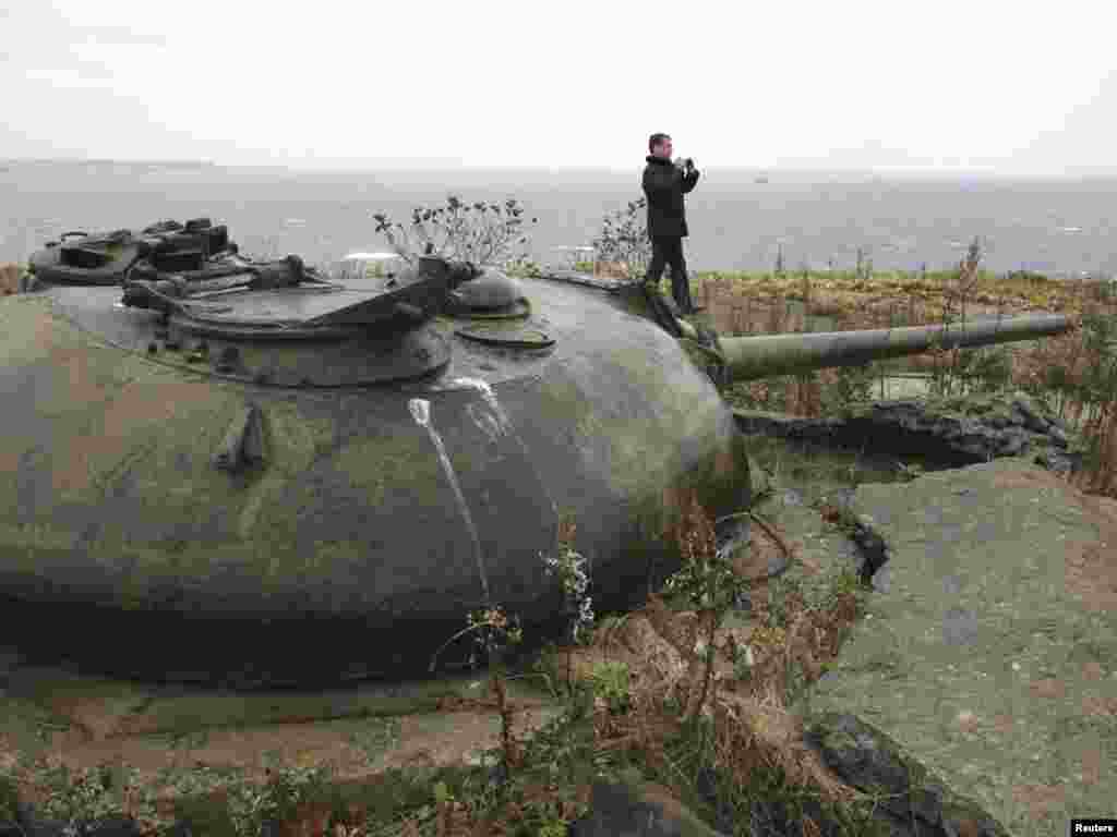 Russia's President Dmitry Medvedev takes pictures near Soviet-made Cold War-era defense turrets, during his visit to Kunashiri Island, one of four islands known as the Southern Kuriles in Russia and Northern Territories in Japan, on November 1. Photo by Mikhail Klimentyev for Reuters