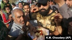 Supporters of former Pakistani Prime Minister Nawaz Sharif distribute sweets to celebrate a supreme court decision, outside the Kot Lakpat jail in Lahore on March 26.
