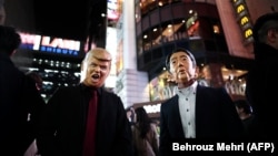 Дональд Трамптын жана Синзо Абэнин келбетин кийгендер Токиодо. 29-октябрь, 2016-жыл.