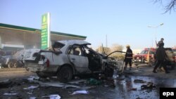 Afghan security officials inspect the site of a bomb blast that targeted the vehicle of a provincial court Judge in Jalalabad on January 7.