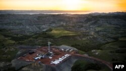 Нефтебуровая установка с высоты птичьего полета в ранние утренние часы 30 июля 2013 года в районе Уотфорд Сити, Северная Дакота. Иллюстративное фото