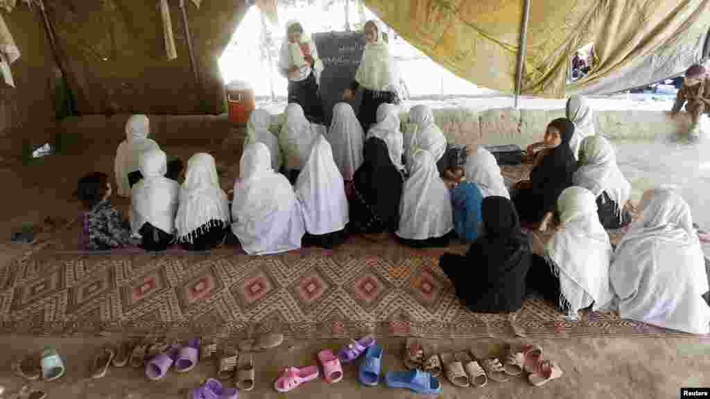 Female students attend classes in a tent in Jalalabad, Afghanistan.