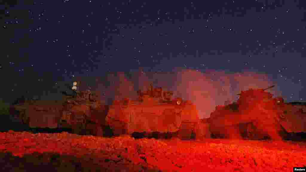 German Bundeswehr Army soldiers walk in front of an armored personnel carrier at a combat outpost near Baghlan in northern Afghanistan. (Reuters/Fabrizio Bensch)