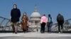 Люди в масках на Мосту тисячоліття в Лондоні під час кризи з коронавірусом