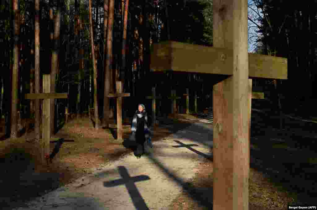 A woman walks past crosses at a Soviet-era mass grave site in Kuropaty in the capital Belarusian capital, Minsk. (AFP/Sergei Gapon)