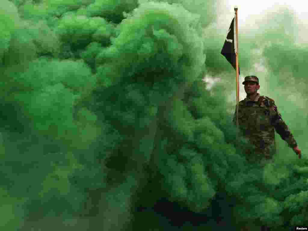 An Afghan National Army recruit marches through green-colored smoke during a graduation parade at the Ghazi military training center in Kabul on February 3. Photo by Ahmad Masood for Reuters
