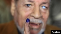 A man shows his ink-stained finger after casting his vote at a polling station in Cairo.