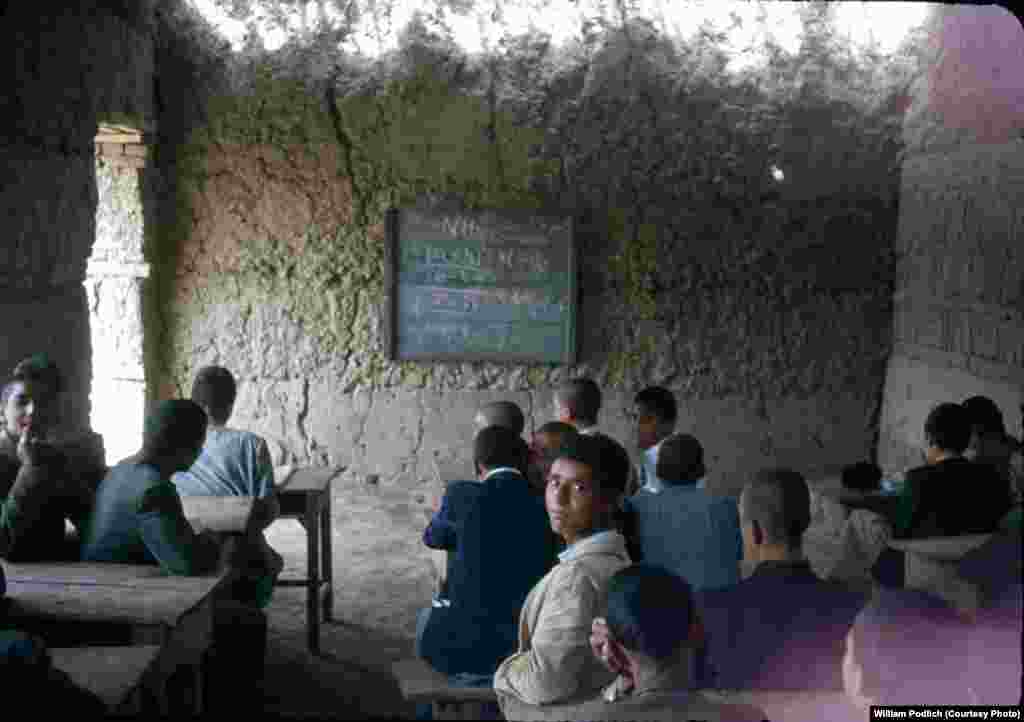 Afghan students learn chemistry in a mud-walled classroom.