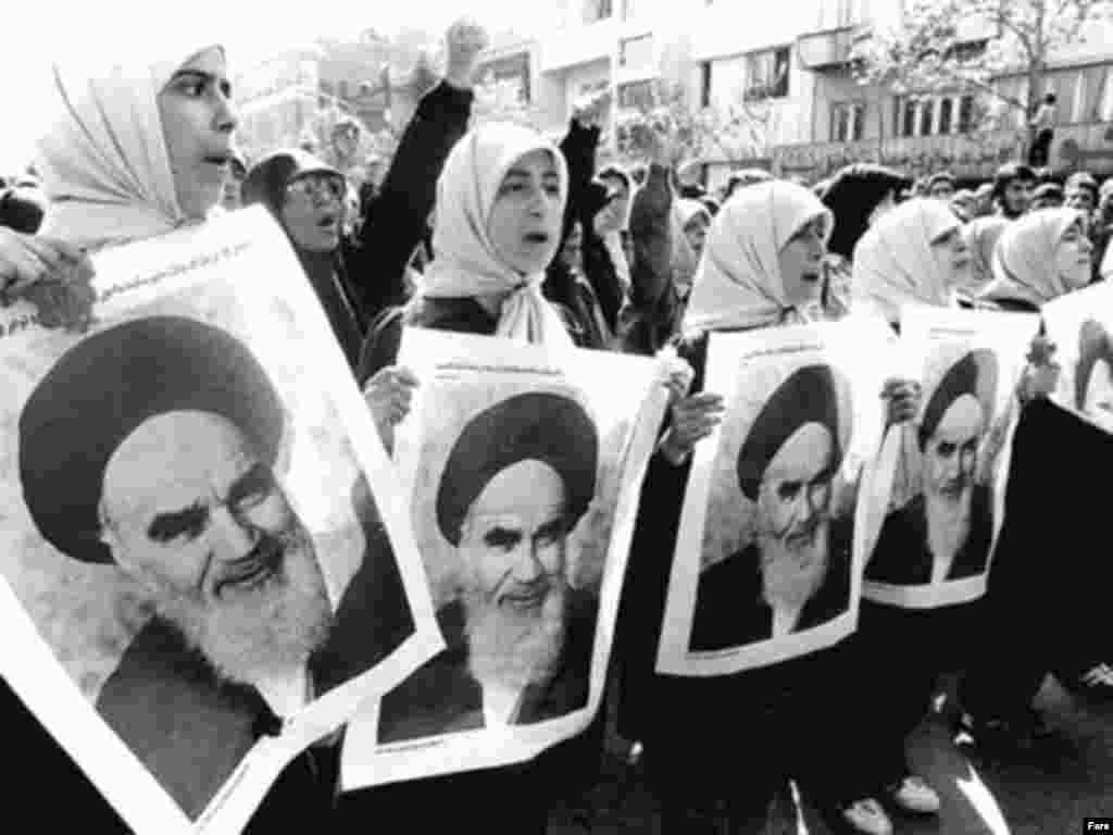 Women hold portraits of Khomeini in 1979.