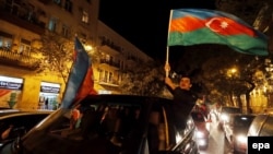 Supporters of Azerbaijani President Ilham Aliyev celebrate in the capital, Baku, after polls closed on October 9.