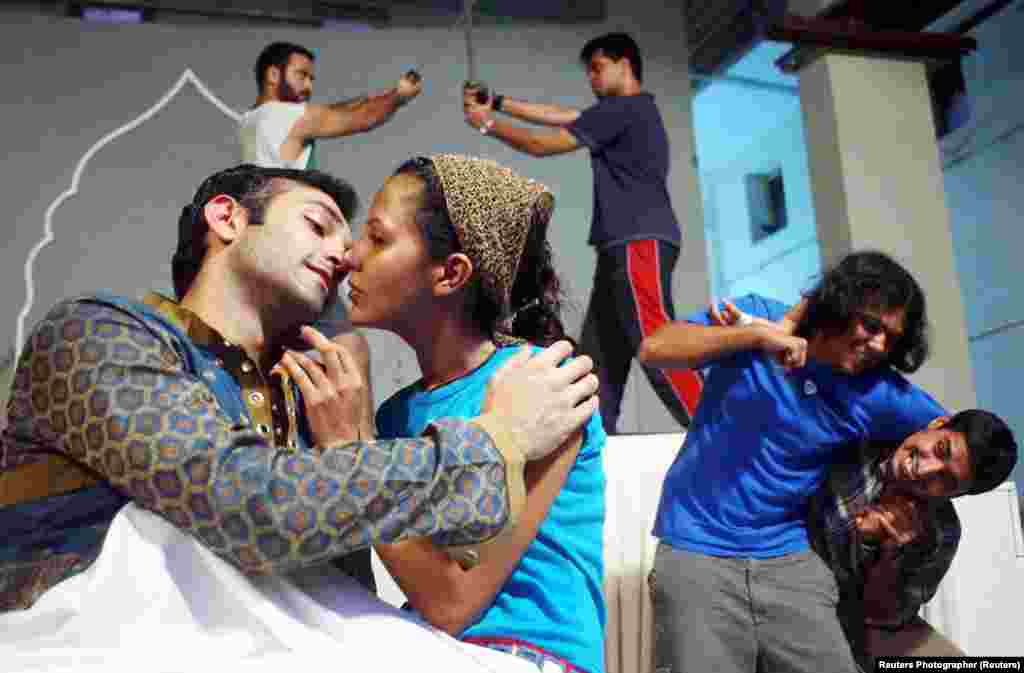 Actors play the roles of star-crossed lovers Romeo and Juliet as other performances stage-fight during a rehearsal in Mumbai. In this staging of the play, the director made the leading roles a Muslim Romeo and a Hindu Juliet.