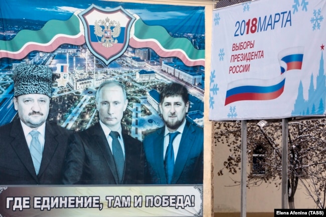 Плакат с Ахматом Кадыровым, Владимиром Путиным и Рамзаном Кадыровым в Грозном перед президентскими выборами 2018 года