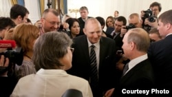 Andrei Stolbunov (wearing glasses) stands next to journalist and environmental activist Mikhail Beketov (center, wearing suit) opposite Russian leader Vladimir Putin at a reception in 2012.