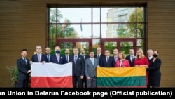 Дипломаты Литвы и Польши позируют со своими национальными флагами после требования властей Беларуси о значительном сокращении дипломатического присутствия Польши и Литвы в Минске, 6 октября 2020 года.