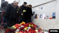 People lay flowers and light candles on the sidewalk in Moscow where Markelov and Baburova were murdered.