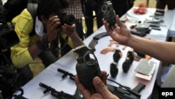 Police officials display arms from suspected criminals in Karachi on March 12, 2014.