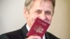 Renumitul balerin Mihail Barîșnikov arătând pașaportul leton primit după ce i s-a acordat cetățenia letonă la Riga, 27 aprilie 2017