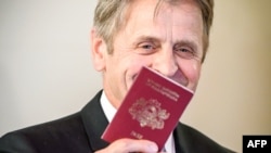 Mikhail Baryshnikov poses with his Latvian passport after he was granted citizenship in Riga on April 27.