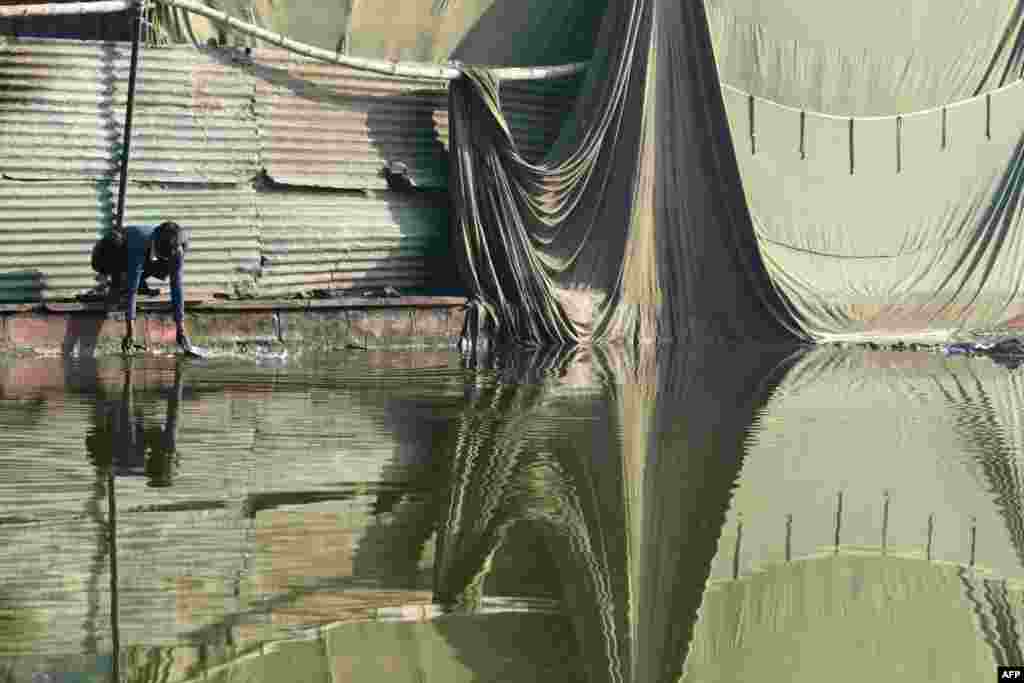 An Indian man washes dishes in an ornamental pond in central New Delhi. (AFP/Dominique Faget)