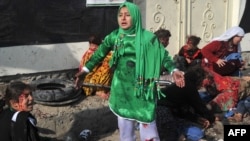 Injured women and young girls cry near the dead and injured from the Kabul explosion.