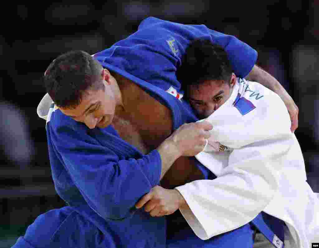 Varlan Liparteliani of Georgia (in blue) and Mashu Baker of Japan clash in the men's 90-kilogram final in judo. Baker, whose father is American, won the gold medal.