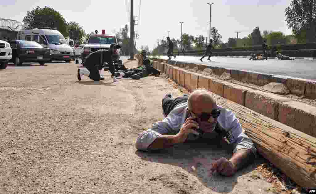 People and soldiers lie on the ground for cover at the scene of an attack on a military parade on September 22 in the southwestern Iranian city of Ahvaz that was marking the anniversary of the outbreak of its devastating war with Iraq. At least 25 people were killed. (AFP/ISNA /Behrad Qasemi)