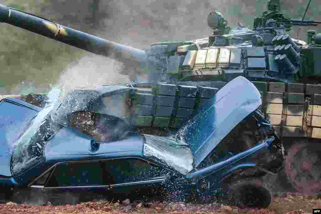 A Belarusian T-72 tank crushes a car during a tank-biathlon competition at the Stalin&#39;s Line museum outside Minsk. (AFP/Maksim Malinovsky)