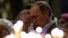 Russian President Vladimir Putin crosses himself as he attends an Orthodox Christmas service at the Holy Face of Christ the Savior Church in the southern Russian city of Sochi early on January 7.